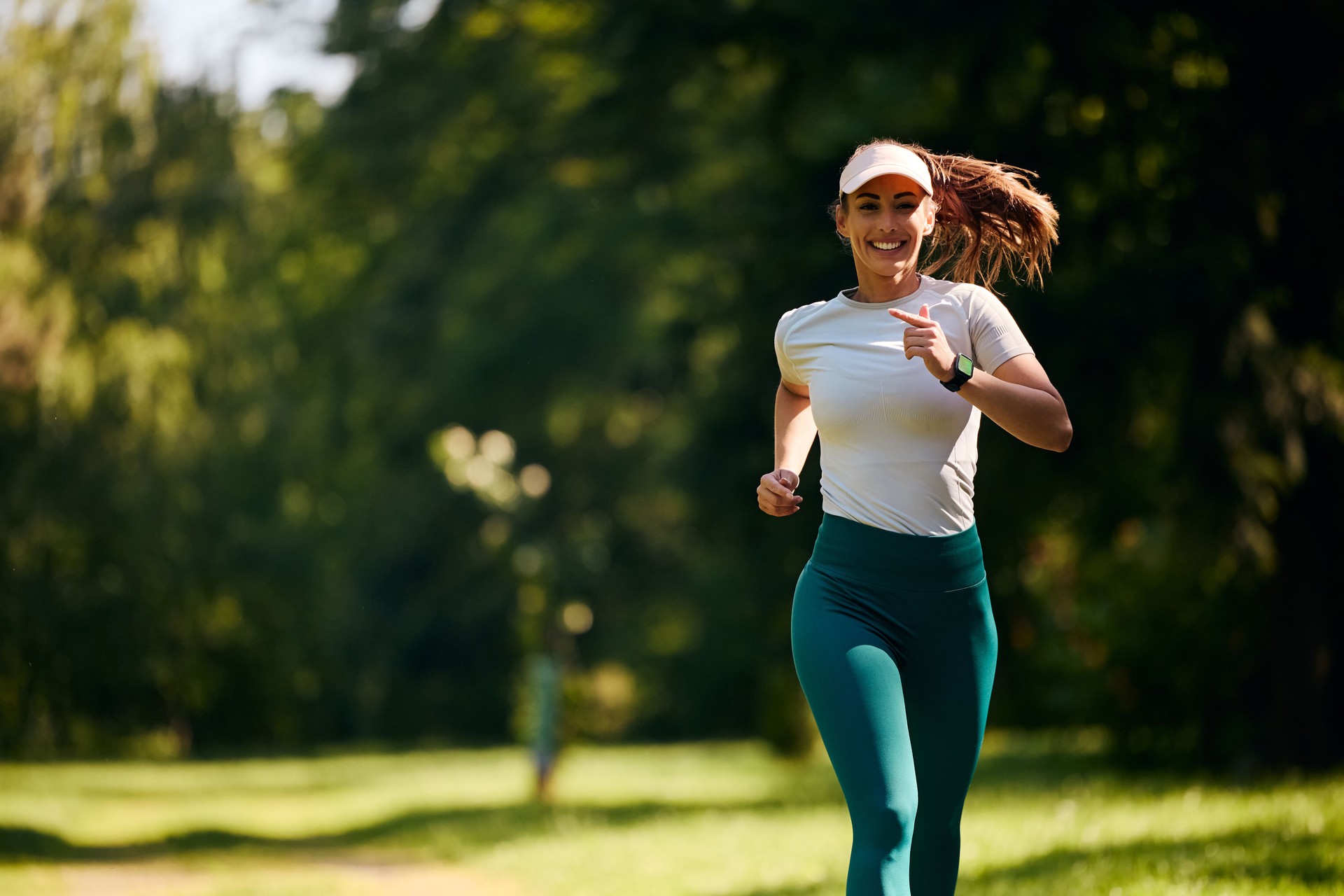 Glückliche Athletin, die im Park läuft.